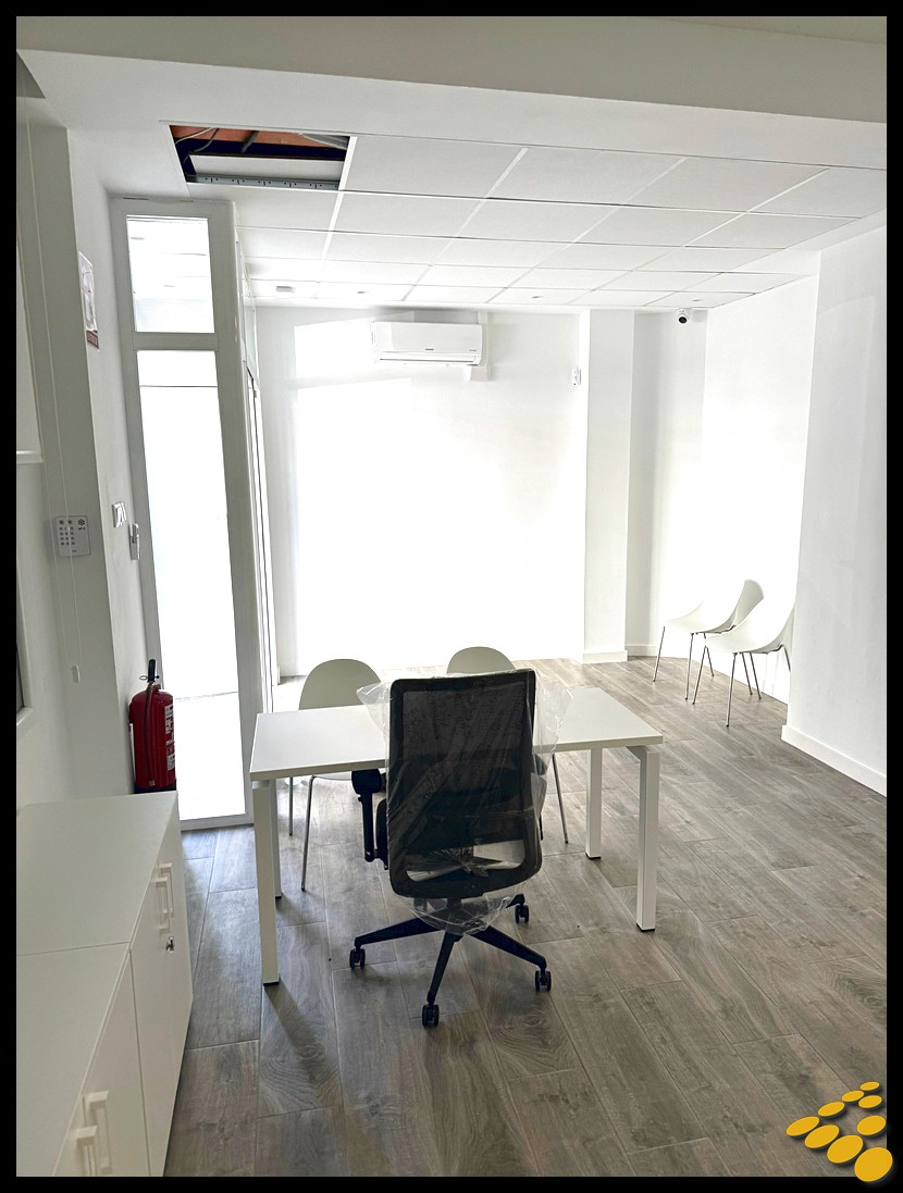 Pasillo final con iluminación renovada en oficina de la Calle Colón