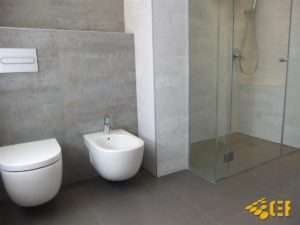Zona de ducha en baño de diseño realizado en Valencia. Váter y bidé empotrados. Ducha con mampara de cristal.